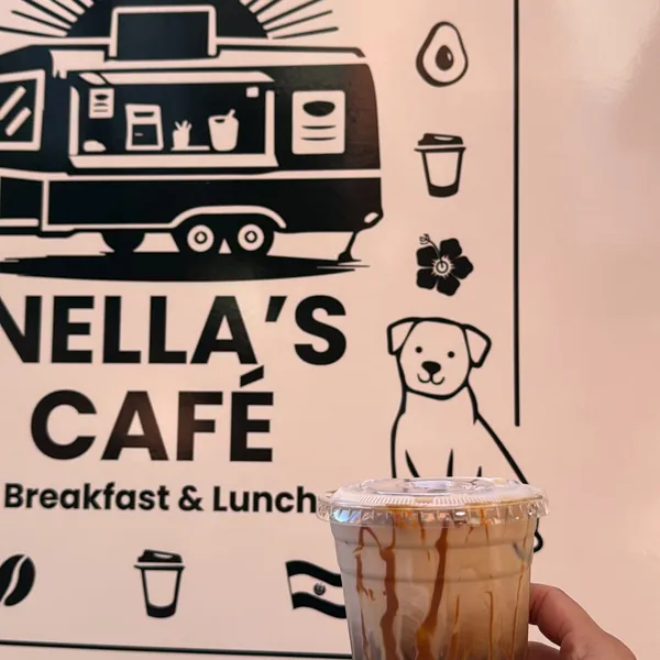 Iced coffee held up beside the Nella’s Café trailer